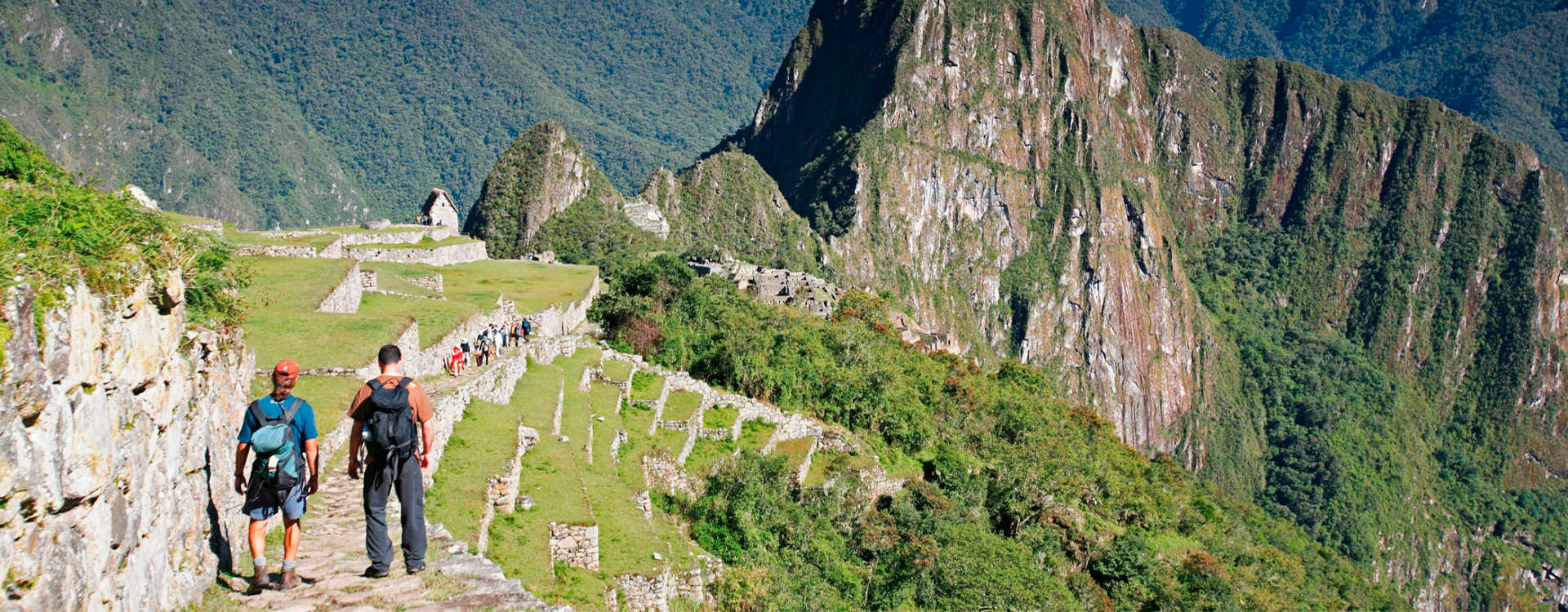 Travelers walking through the Inca ruins at Machu Picchu